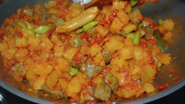 Cooking Indonesian traditional food named "Sambal Goreng Ati Ampela Pete" i.e. Hot spicy chicken gizzard and heart cooked with bitter bean