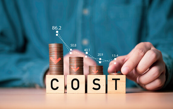 Businessman putting decreasing coins stacking with down arrow for cost reduction concept which effect to product cost , profit , inflation and economy recession concept.