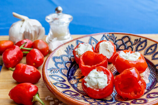 Fresh and preserved sweet piquante peppers filled with cottage or cream cheese on a decorated ceramic plate