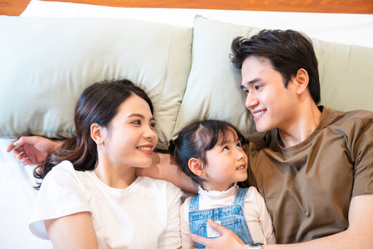 Happy family bonding: Mom dad and daughter share a loving moment together on the cozy bed