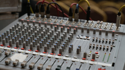A professional audio mixing console with multiple knobs, buttons, and sliders, used for sound control in music production, broadcasting, and live events.