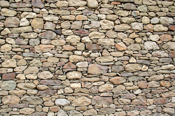 Fragment of stonework without mortar. Wall of stones laid without mortar. Stones laid in a wall