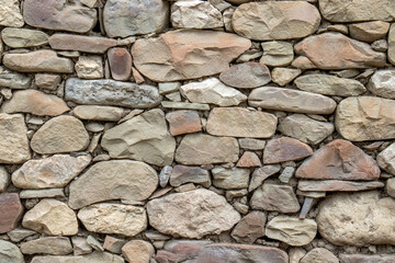 Fragment of stonework without mortar. Wall of stones laid without mortar. Stones laid in a wall