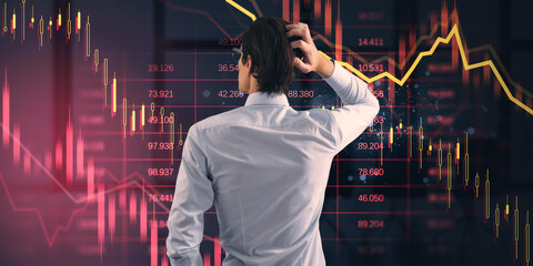 Businessperson looking at falling stock market chart with financial data on dark background, representing economic crisis and uncertainty.