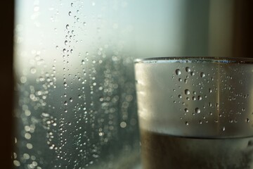A glass of water sitting on top of a window sill