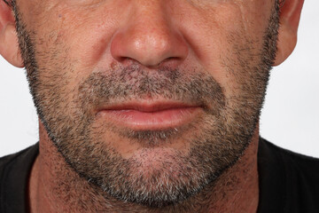 Obraz premium Lower face of a 45-year-old man with light stubble, showing natural facial texture