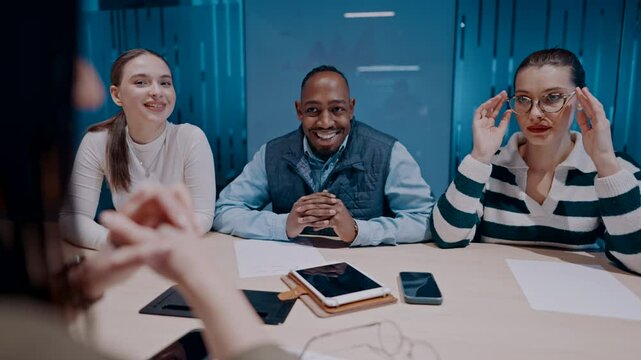 A diverse team of young professionals collaborates in a modern office conference room. Businesspeople discuss strategy, technology, and planning, using laptops to develop an innovative e-commerce