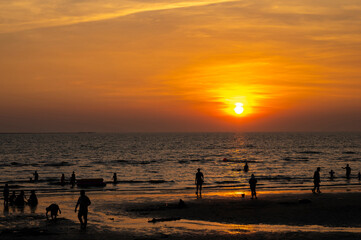 Silhouette photos are many people on the beach at sunset.
