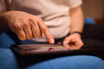 User Engaging with a Touchscreen Device While Relaxing in a Cozy and Inviting Setting © Евгений Вершинин