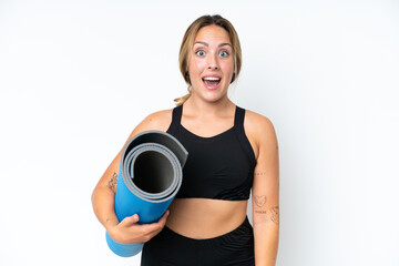 Young caucasian woman going to yoga classes while holding a mat isolated on white background with...