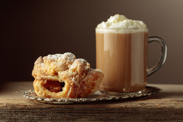 Viennese strudel and coffee latte on an old wooden table.