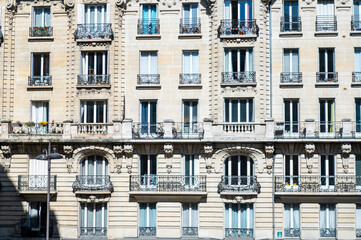 Façade ensoleillée d'immeuble ancien à Paris avec balcons ouvragés