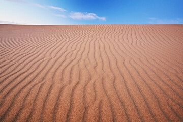 Minimalistic landscape: sandy desert and blue sky