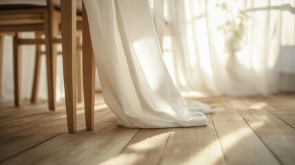 A white tablecloth hanging down from a wooden table