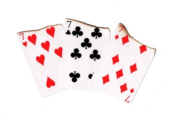 A hand of three burnt playing cards of the same value.