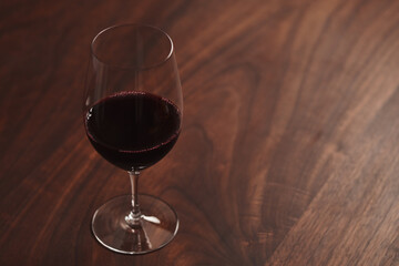 Red wine in thin wine glass on wood table