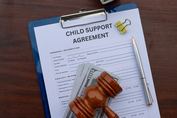 A formal child support contract placed in a clipboard on an office desk, highlighting legal and...