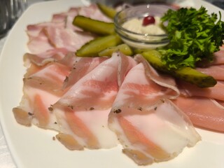Delicious sliced meat on a plate with herbs