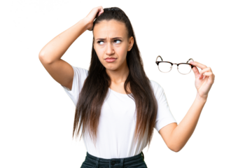 Young Arabian woman holding glasses over isolated chroma key background having doubts and with confuse face expression