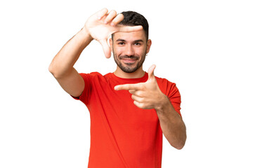 Young handsome caucasian man over isolated chroma key background focusing face. Framing symbol