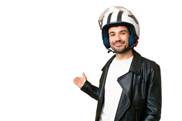 Young caucasian man with a motorcycle helmet over isolated chroma key background extending hands to the side for inviting to come