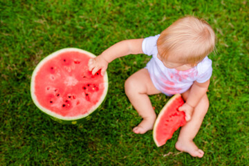 Little one enjoying summer treat with big bite of watermelon