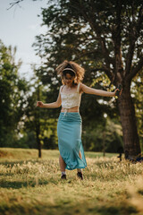 A young woman performs a modern dance in a sunlit park, capturing joy and freedom amidst nature....