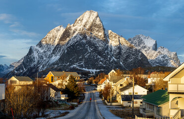 Goldene Stunde in Reine auf den Lofoten in Norwegen mit verschneiter Straße zum Olstinden im...