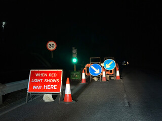 Temporary traffic lights with a when red light shows wait here sign on a residential street.