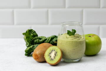 Fresh green smoothie with kiwi and apple on white background