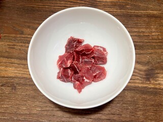 Fresh raw premium beef shank, ingredients for making dishes. Placed in a white ceramic bowl, on a wooden table.