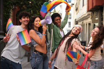 Obraz premium Group of happy multi ethnic friends celebrating gay pride holding rainbow flags and megaphone