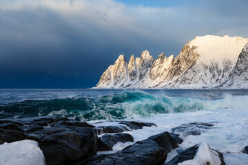 Die Okshornan auf Senja in Norwegen zur goldenen Stunde, im Licht leuchtend vor einem aufziehenden...