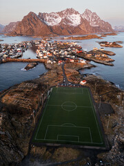 Henningsvær auf den Lofoten in Norwegen bei klarem Himmel am Morgen, die verschneiten Berge und...