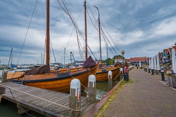 View of fishing boats in Volendam harbor under cloudy skies