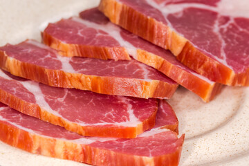 Slices of dry-cured pork neck, front view close-up