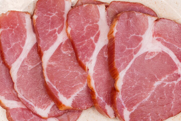 Slices of dry-cured pork neck, top view close-up