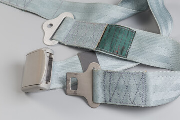 Unfastened buckle of airplane lap seat belt on gray background