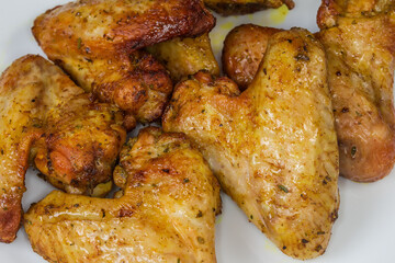 Baked chicken wings on the dish, fragment close-up