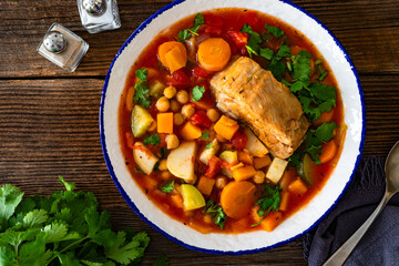 Fresh vegetable soup with chickpeas and meat on wooden table	