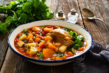 Fresh vegetable soup with chickpeas and meat on wooden table	
