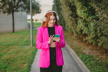 An Uniquely Stylish Young Woman Happily Enjoying Music While Leisurely Walking Outdoors
