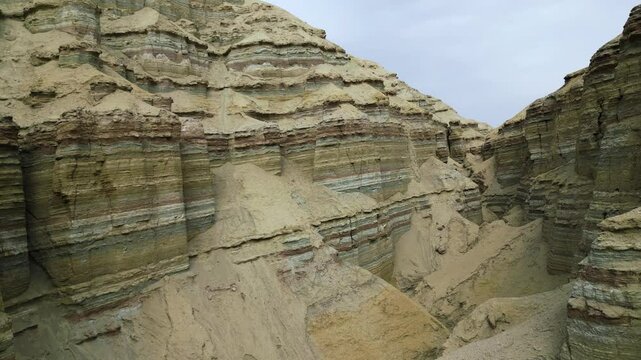Unusual sandy layered mountains. Flying over the yellow canyon. Colorful sedimentary rocks. Altyn Emel National Park. Kazakhstan