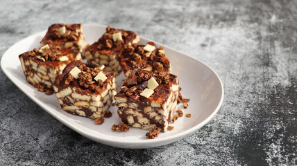 Lazy cake or mosaic cake with granola and chocolate . Homemade no bake chocolate biscuit cake on a table
