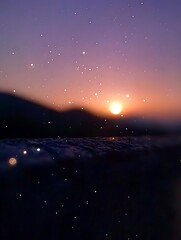 A colorful sunset scene over a dark mountain silhouette