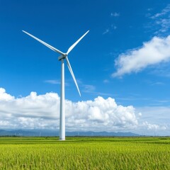 A tall white wind turbine stands in a vibrant green rice paddy under a bright blue sky with fluffy white clouds. Other turbines are visible in the distance.