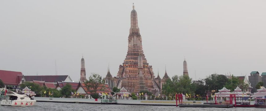 Wat Arun (Temple of Dawn) in Bangkok, Thailand, captured from across the Chao Phraya River. The temple's iconic central prang is prominently featured.