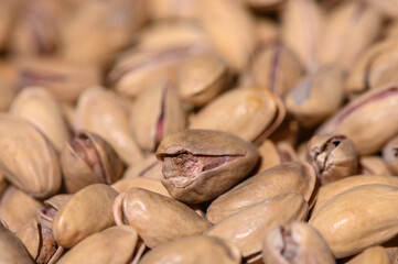 Close-up view of unshelled pistachio nuts scattered on the surface, showcasing their unique textures and colors