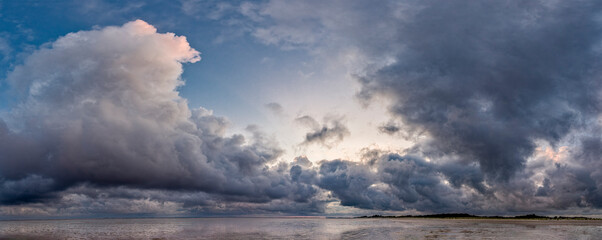 Ein Orkantief mit dramatischen Gewitterwolken zieht über das Watt der Nordseeinsel Föhr
