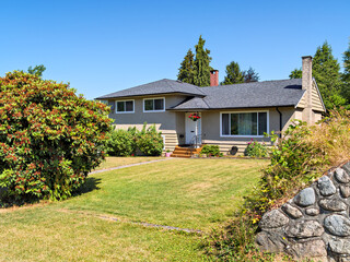 A perfect neighborhood. Neat residential house with flowers mowed front yard lawn